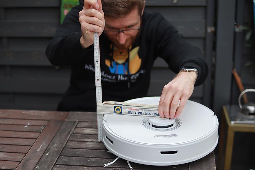 Der Roborock Q7 Max Staubsauger-Roboter wird mit einem Lineal ausgemessen